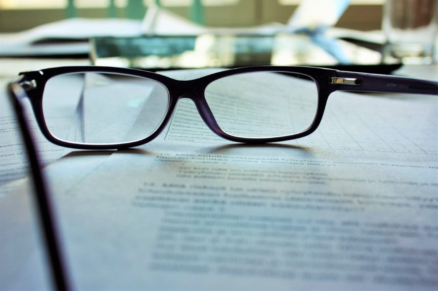 Contrato sobre uma mesa com um par de óculos sobre o contrato.